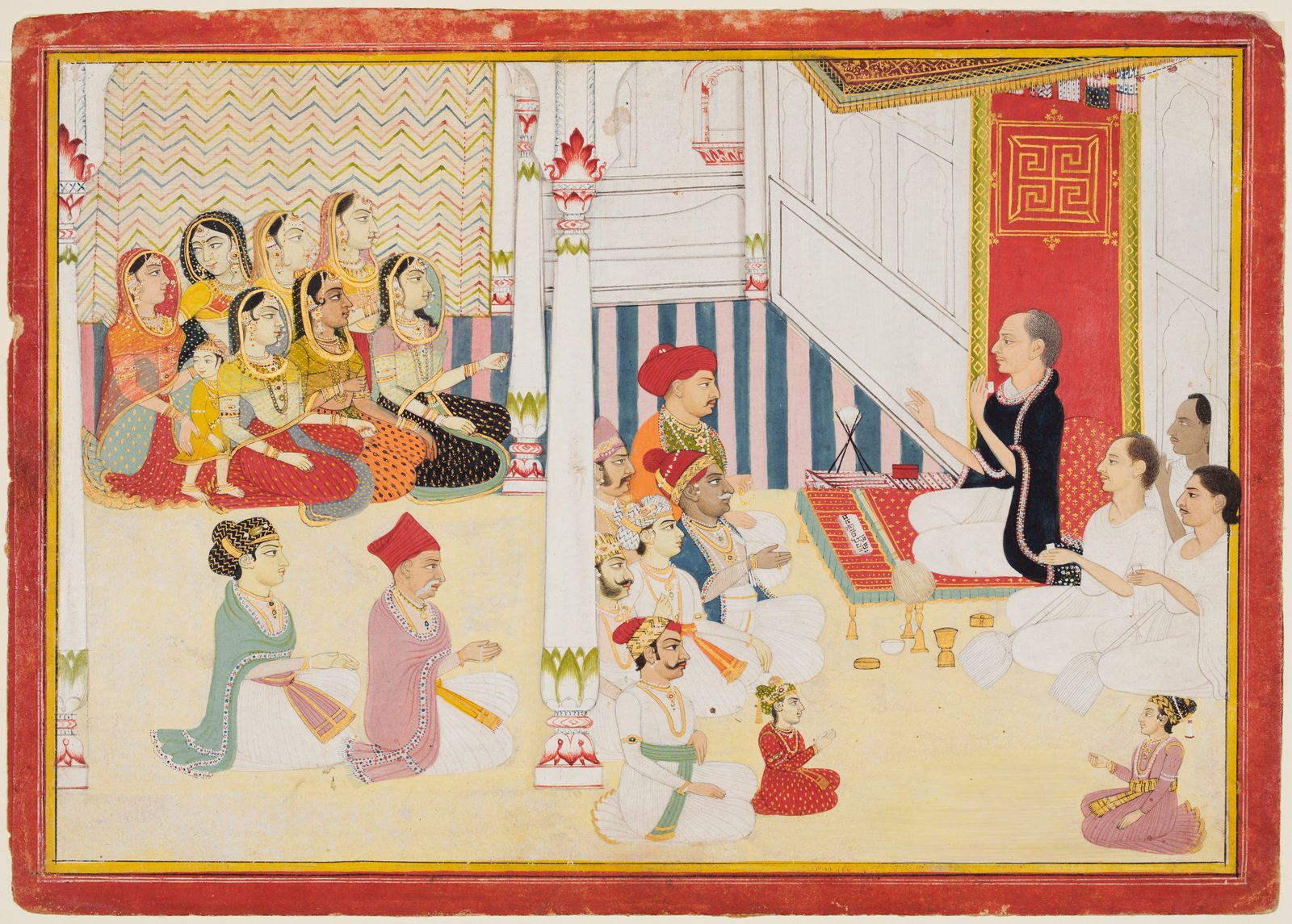An Indian miniature painting inside a red and yellow border. At the right a teacher in a dark shawl sits on a low platform with an open manuscript on a small red stand in front of him, one hand raised in the gesture of discourse. Facing him across the floor sit rows of listeners: men in turbans and white robes in the foreground, a child in red among them, and a group of women in coloured saris and jewellery gathered behind marble pillars on the left.