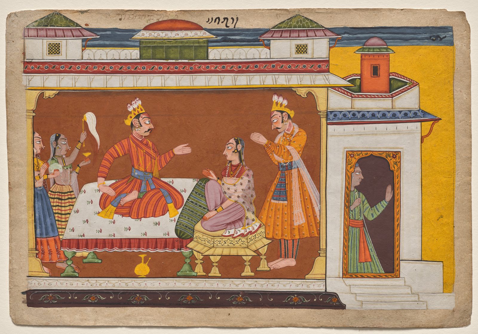 A Pahari folio painting on aged cream paper, wider than it is tall, with worn edges. Inside a room with a deep brown wall, a crowned king in a striped orange robe sits on a low white bed and leans forward with one hand out, speaking. Facing him, a woman in a pale flowered veil sits on a small yellow stool with her palms raised. A second crowned figure in orange stands just behind her, one hand lifted. Two women wait at the left, with a third behind them holding up a white fly whisk. At the right, outside the room, a figure in a green striped robe stands in a dark doorway at the top of a short flight of steps. Green-domed pavilions and a narrow band of dark sky run along the top, and a short line of script is written in the margin above.
