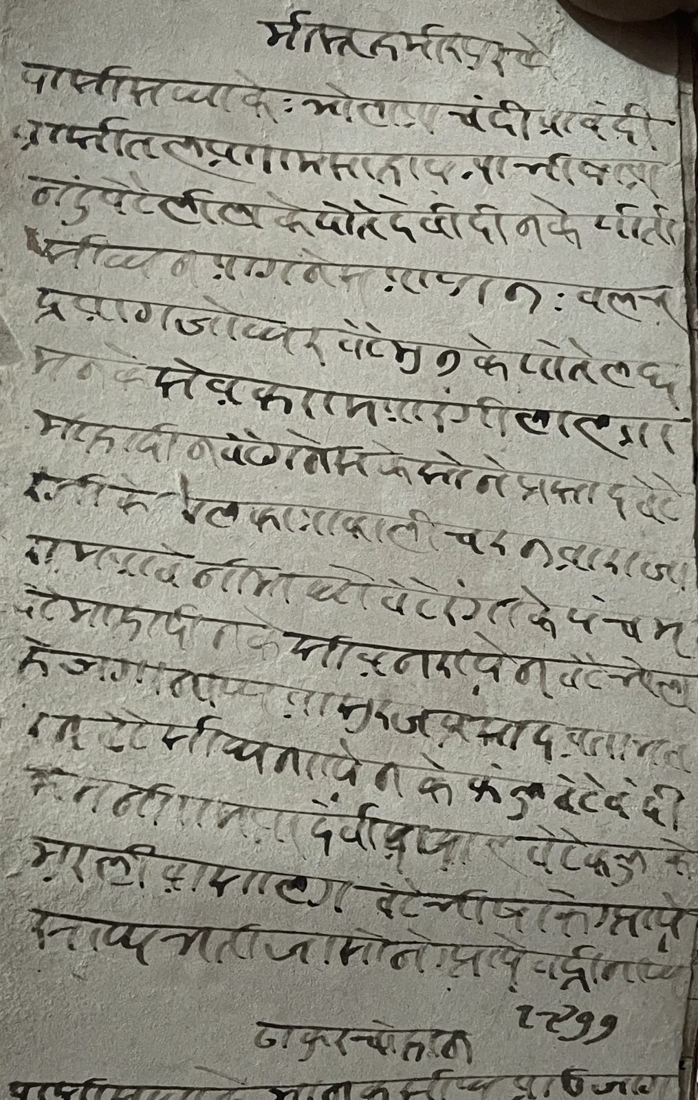 A tall folio from a handwritten Indian genealogical register, the aged paper browned and worn at the edges and covered from top to bottom with closely spaced lines of handwriting in dark ink.
