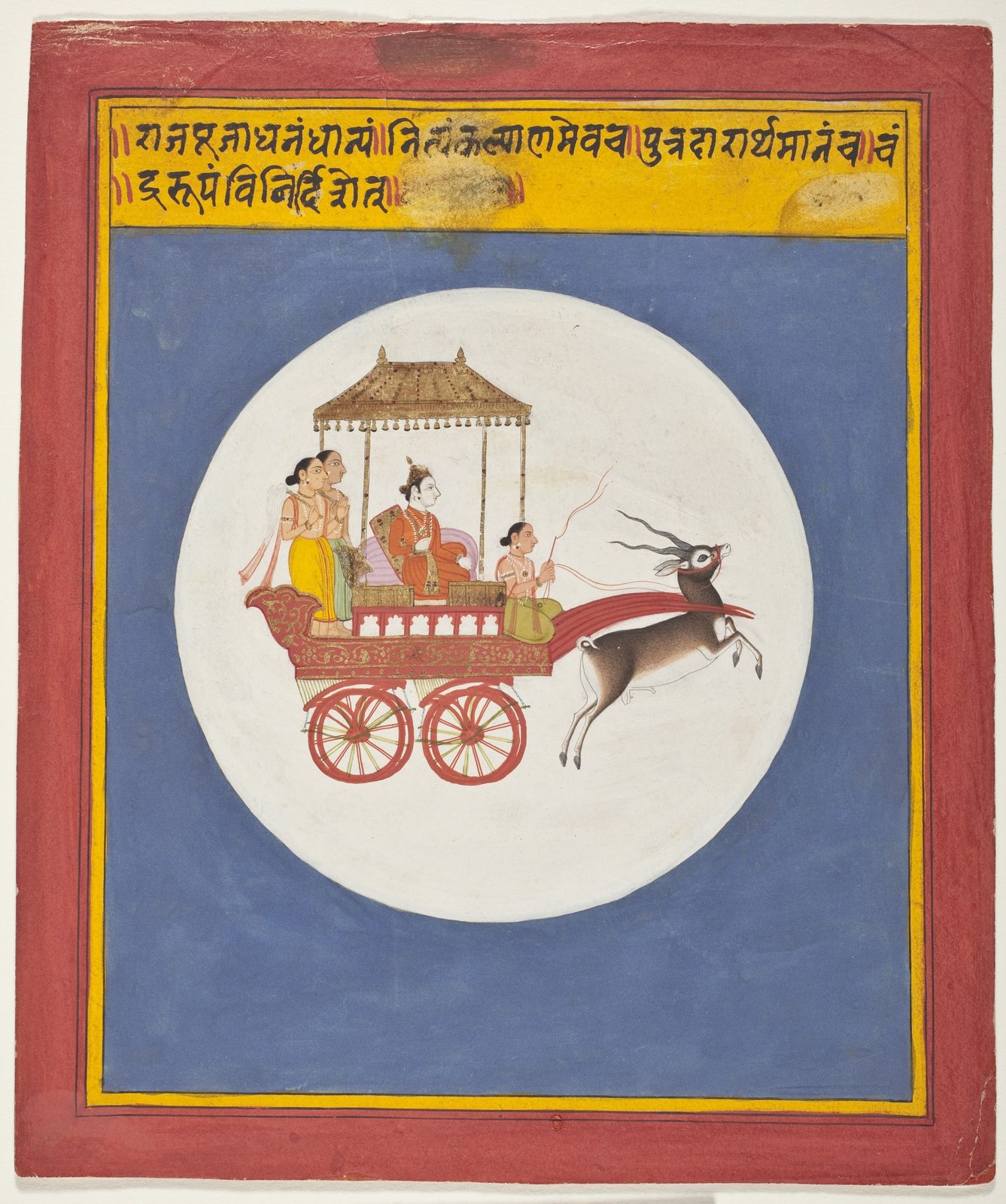 An Indian miniature painting in opaque watercolour, gold and ink. Inside a large white disc set on a deep blue ground, a crowned figure in orange sits under a gold canopy on a red, gold-worked chariot with two spoked wheels; attendants stand behind him and a driver at the front holds red reins. A single antelope with long spiralled horns springs forward, drawing the chariot. A red and yellow border frames the page, with a line of Devanagari script across the top.