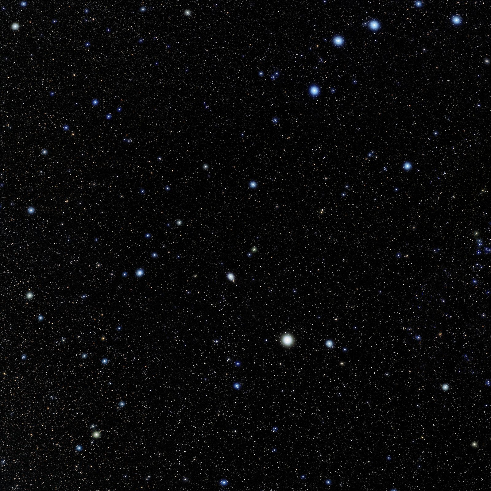 A wide colour photograph of a dense star field on a near-black sky. One star is far brighter than everything else in the frame and is distinctly amber; a long narrow kite of fainter white stars reaches away from it. Thousands of much fainter pinpoints fill the rest of the field.